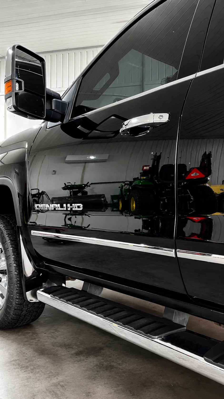 Mirror reflection along the side of a black GMC Denali HD